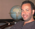 Headshot of Nathan Wolfe, globe in background