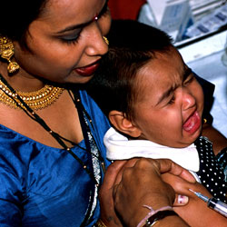 Woman holds screaming baby receiving a shot in the arm