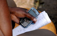 Close up fo hand holding mobile phone and paper printed with data