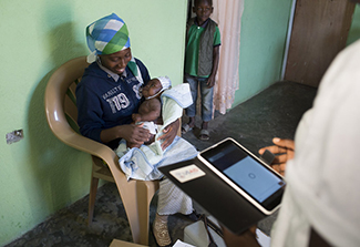 mother and child sitting in a chair while data is being taken on mobile device