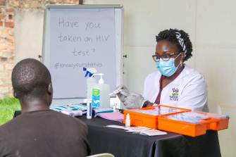Dr. Patience A. Muwanguzi doing HIV testing with a patient
