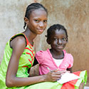 Courtesy of istock, Two African girls look at camera, one is writing