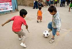 Two boys play soccer in the street in Peru.
