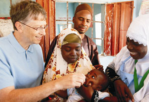 Bill Gates administers polio vaccine to baby, held by mother, another man and woman look on