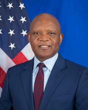 Headshot of John Nkengasong wearing a dark jacket and dark red tie