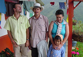A family in Colombia on the porch, mountains in background.