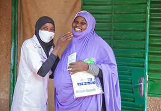 A pregnant woman receives a mosquito net at her prenatal visit to help protect her from malaria.