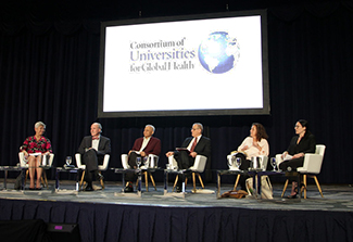 Participants sit on a stage at the plenary session at CUGH 2023 on global health in the 21st century