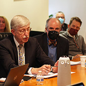 Dr. Francis Collins (left) speaks as Dr. Peter Kilmarx (right) and others listen in.