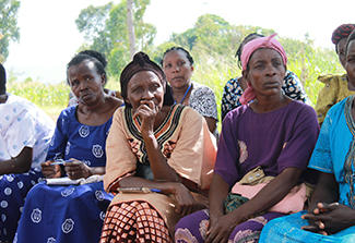 A photo of a group of women listening to a speaker in Uganda