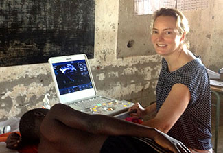 Dr. Amy Sims Sanyahumbi works with ultrasound machine while patient lies on side