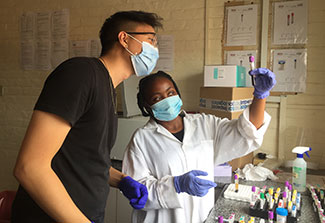 Andrew Kim working with samples in a lab with a colleagu