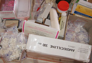 Large pile of pills, boxes and tubes, side of one box reads amoxicilline 500 mg