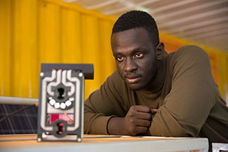 Brian Gitta observes a malaria detection prototype.