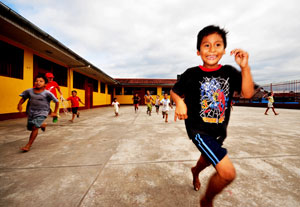 Children happily run and play outside in a school courtyard