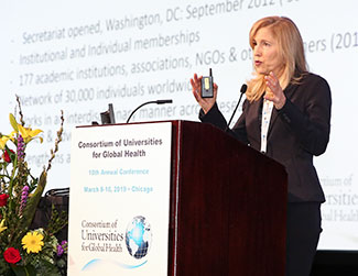 Dr. Ann Kurth speaks at a podium at the CUGH 2019 annual meeting.