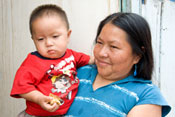 Mother holds baby, both look at camera