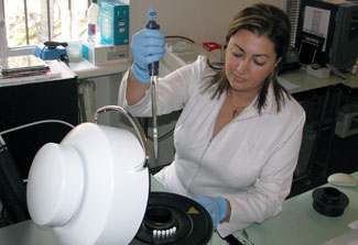 A female researcher wearing gloves works with samples in a lab in Georgia