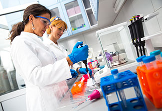 Two female scientists researching in laboratory.