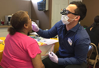 Healthcare worker performs test on health fair participant.