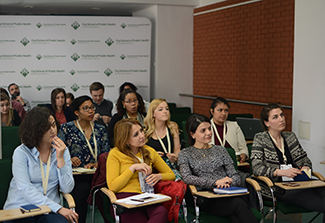 This photo shows students, mostly women, sitting in rows listening to a lecture in a classroom of the iCREATE summer school. 