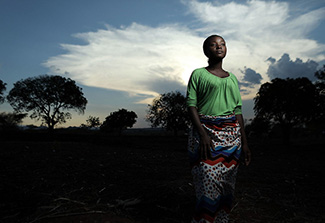 Photo shows Maggie Medison, an 18-year-old peer educator, standing against a backdrop of trees and sky.