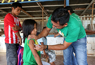 Medical worker gives girl a shot in her arm in Brazil