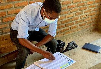 A man takes a survey as part of a home-based HIV intervention in Malawi.