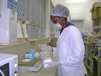 Dr. Tariro Mawoza-Chikuni works with substances in a lab.