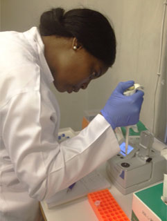 Dr. Tsitsi Monera-Penduka works with samples in a lab.