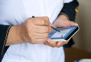 Close-up of hands entering data using mobile device and stylus