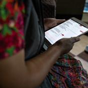 Close up of a tablet held by a woman in a dress
