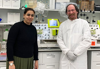 Dr. Albeena Nisa (left) and  Larry Moses (right) smile for a photo in the NCI lab
