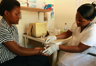 nurse in golves collects sample from patient in a lab setting