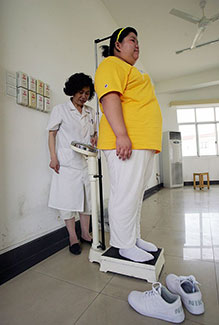 A child is being weighed by a medical worker at a base of the Aimin Slimming Centre in Wuhan of Hubei Province, China.