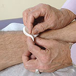 Close up of hands administering acupuncture.
