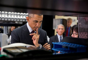 Closeup of President Barack Obama touring NIH Vaccine Research Center, listening attentively to researcher