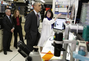 President Barack Obama tours NIH Vaccine Research Center, listens attentively to researcher