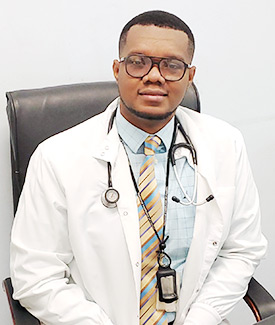 Yvetot Joseph  wears a white lab coat in his office at GHESKIO in Port-au-Prince, Haiti