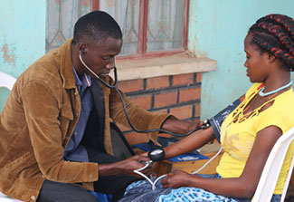 Medical worker takes a participant’s blood pressure.