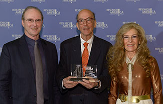 Tom Hutton and Mara Hutton of the Geoffrey Beene Foundation pose with Roger Glass, who holds his award