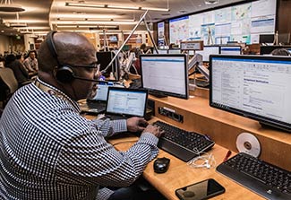 Person works with many computers in CDC Emergency Operations Center responding to coronavirus disease 2019 COVID-19 outbreak.