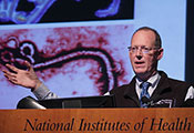Paul Farmer speaking at a podium at NIH, slide projected in the background