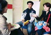 Male and female, who holds infant in lap, meet with clinician in an office