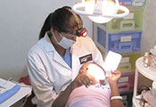 Dr Lilliam Pinzón performs a dental exam for a child in a reclined dental chair