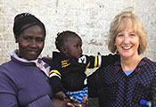 Dr. Debra Litzelman pictured with woman holding a baby at a research site in Kenya