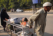 A man and woman push a stretcher holding an injured man through the streets of Chandigarh, India.