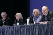 Panel of leaders from across NIH sit at long conference table on stage, some speak into microphones, look pleasant, engaged