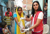 Dr. Arti Kundu collects samples from hand surfaces using a bag of sterile water from a female study participant in a busy street