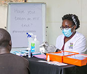 Photo courtesy of Racheal Nabunya. Dr. Patience A. Muwanguzi pointing to test results meets with a patient in a clinic.